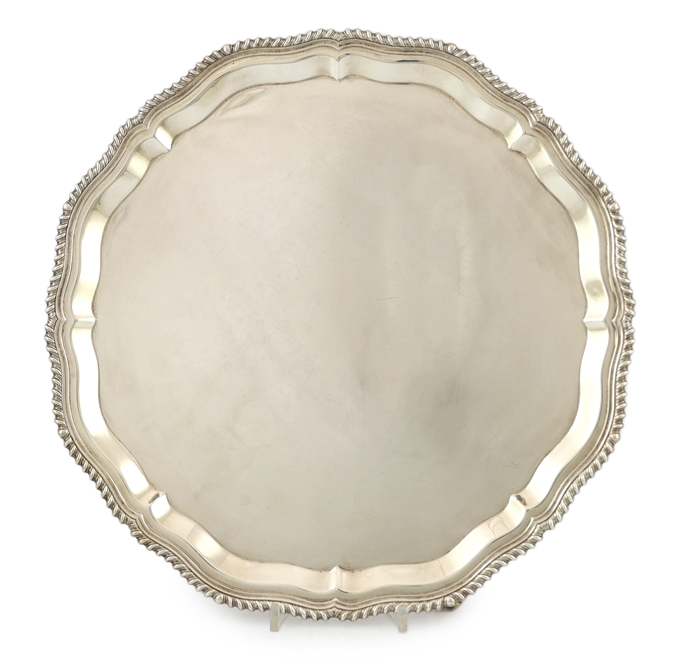 A large Elizabeth II circular silver salver, with piecrust and gadrooned edge, on four scrolled feet, by J.B. Chatterley & Sons Ltd